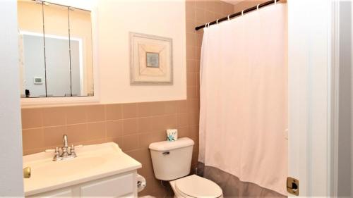a bathroom with a toilet and a sink at Fairwinds Cottage in Cape May