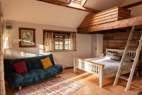 a bedroom with a bunk bed and a couch at sika lodge in Wareham