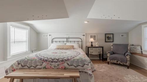 a bedroom with a large bed and a chair at Little Cottage On Lafayette in Cape May