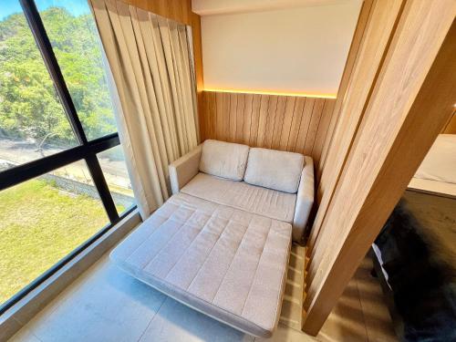 a small room with a couch in front of a window at Cabo Branco - Legacy Suítes in João Pessoa