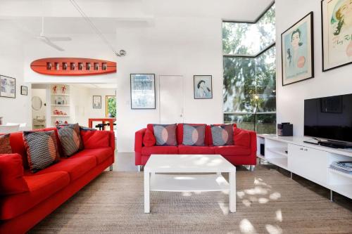 a living room with red couches and a tv at A AAA Coke Shack in Point Lookout