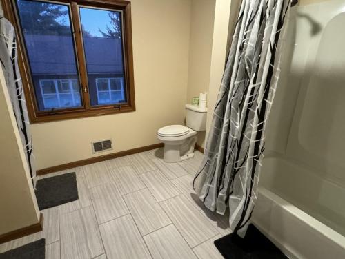 a bathroom with a toilet and a shower curtain at Studio 6 Lake George NY Adirondacks in Lake George