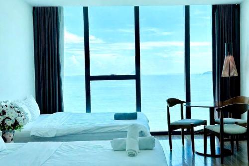 a bedroom with two beds and a table and chairs at AHoa StarCity with Seaview in Nha Trang