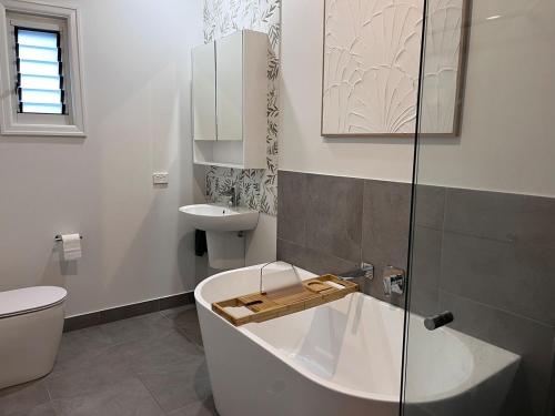 a bathroom with a tub and a toilet and a sink at Hathaway House in Toowoomba