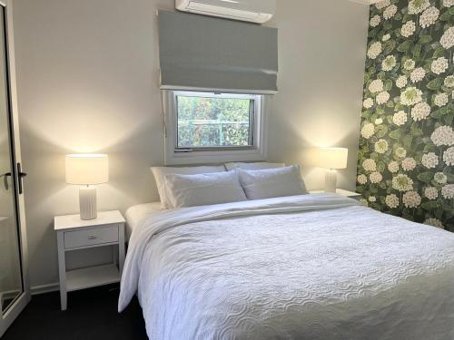 a bedroom with a white bed and a window at Hathaway House in Toowoomba