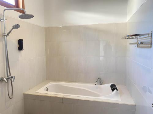a white bath tub in a bathroom at Villa Sinyo By Mentaripro Bali in Lovina