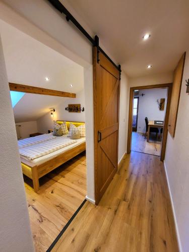 a bedroom with a bed and a sliding barn door at Ferienwohnungen Hörterer | Chiemgau Karte in Grassau