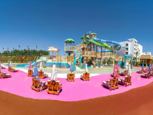 a water park with chairs and a roller coaster at Rixos Radamis Sharm El Sheikh in Sharm El Sheikh