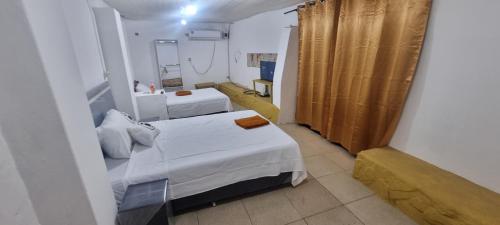 a small room with two beds and a mirror at Depa más pileta en Ypane in Ypane