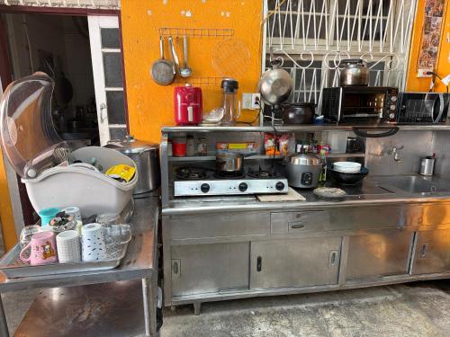 Una cocina con estufa y fregadero. en 背包客棧Backpackers Hostel, en Checheng