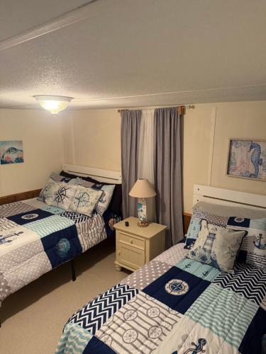 a hotel room with two beds and a table with a lamp at The Revival Retreat in Gloucester