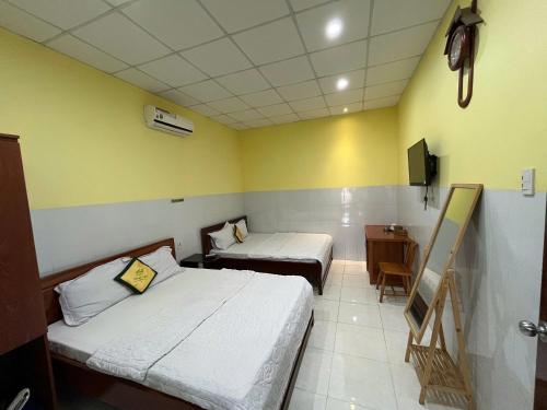 a small room with two beds and a desk at Tan My Thien Hotel in Tây Ninh