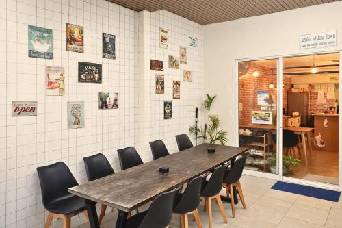 a dining room with a wooden table and chairs at KPOP Hostel in Karon Beach