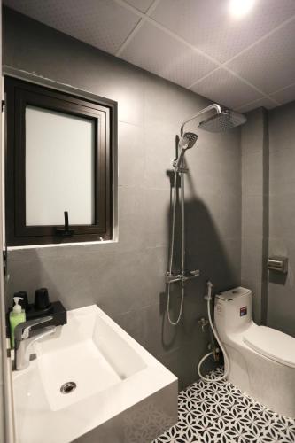 a bathroom with a shower and a sink and a toilet at VITA Homestay in Cat Ba
