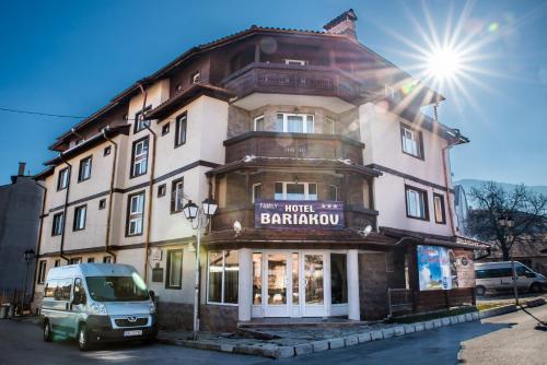 a building with a van parked in front of it at Bariakov Family Hotel in Bansko