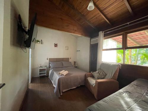 a bedroom with a bed and a couch at Kit luxo com spa aquecido in Florianópolis