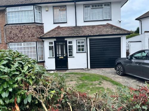 a garage with a car parked in front of a house at Double Room with Garden View at Love & Peace Petts Wood in Orpington