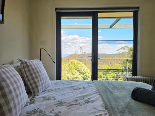 a bedroom with a bed and a large window at Narrow Neck Views - Peaceful 4 Bedroom Home with Stunning Views! in Katoomba