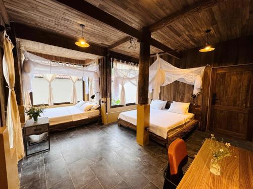 a bedroom with two beds in a room with wooden walls at Nabum Retreat in Làng Giang
