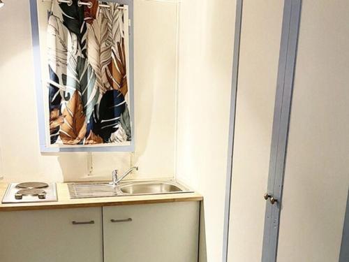 a small kitchen with a sink and a mirror at Maison avec terrasse - 6 pers. - API-1-52-2178 in Lattes