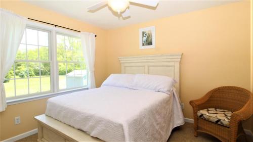 a bedroom with a bed and a window at Fairwinds Cottage in Cape May