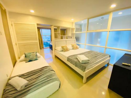 a bedroom with two beds in a room with windows at Cebu City Huge Lofts by P&J in Cebu City