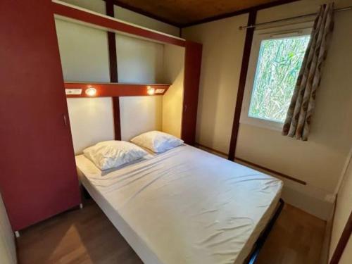a bed in a small room with a window at Chalet avec terrasse - 7 pers. - API-1-52-2181 in Lattes