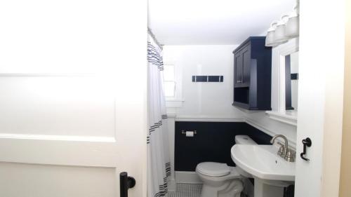 a bathroom with a white toilet and a sink at Gray Cottage On Windsor in Cape May