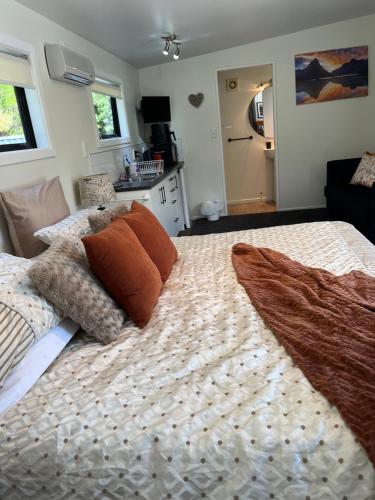 a bedroom with a large bed with pillows on it at Queen Charlotte Bach in Linkwater