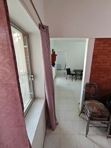 a room with a window and a chair and a table at Bungalow privado con alberca Oaxtepec 14 personas in Oaxtepec