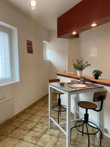 a kitchen with a counter and stools in a room at Maison a Confluence T2BZ-Tram in La Mulatière
