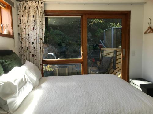 a bedroom with a bed and a large window at Lakeview QT in Queenstown