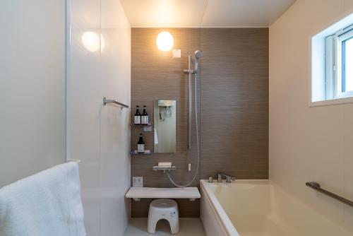 a bathroom with a tub and a shower and a sink at Soga House in Niseko