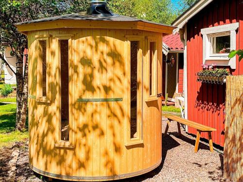 a wooden out house with a bench in a yard at 4 person holiday home in Tibro in Tibro