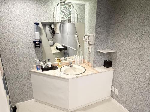 a bathroom with a sink and a mirror at ホテルアクアAdult Only in Hiroshima