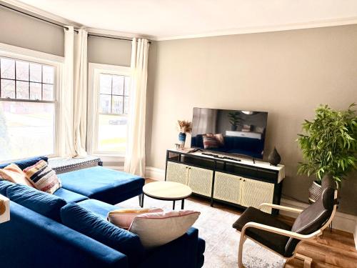 a living room with a blue couch and a tv at Lovely vintage Oak Park 3bd 1ba perfectly located near public transit & Chicago in Oak Park