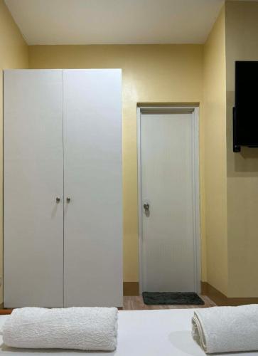 a bedroom with two white cabinets and a television at Boboy's Guest House in Daro