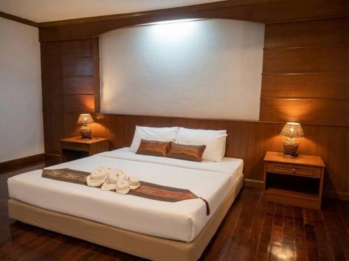 a bedroom with a large bed with two night stands at Lanna Oriental Maejo in Chiang Mai