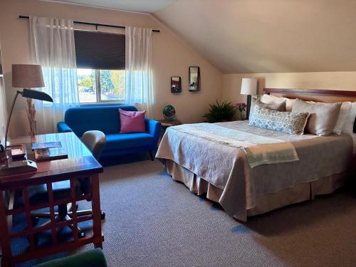 a bedroom with a bed and a couch and a table at Discovery Inn in Friday Harbor