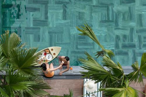 a figurine of a woman holding a surfboard next to a statue at Shining Riverside Hoi An Boutique & Spa in Hoi An
