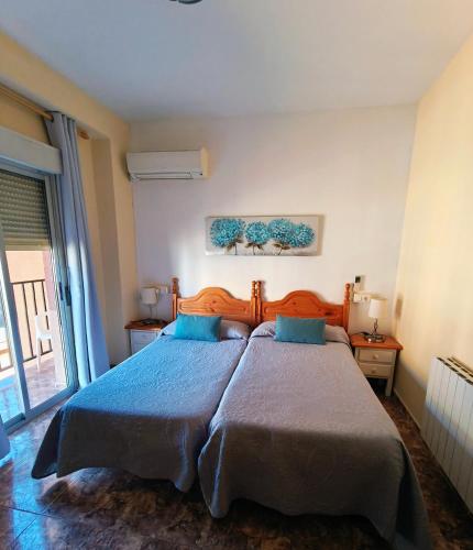 a bedroom with a large bed with blue pillows at Hostal Rural Gloria in Graena