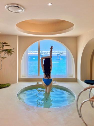 a woman in a swimming pool looking out a window at Meomulda Subyeon in Busan