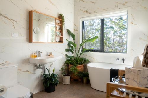 a bathroom with a tub and a sink and a mirror at Studio 216 - Oceanview Studio with Bath, Romantic Bruny Escape in Alonnah