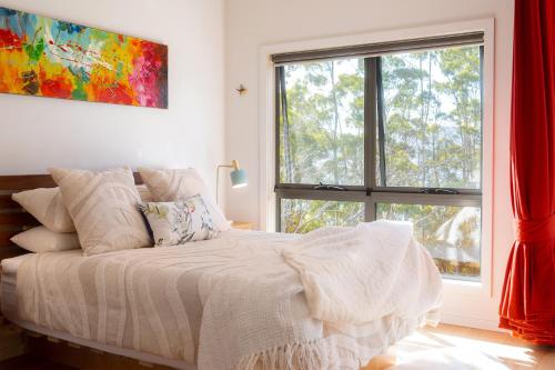 a bedroom with a bed and a large window at Studio 216 - Oceanview Studio with Bath, Romantic Bruny Escape in Alonnah