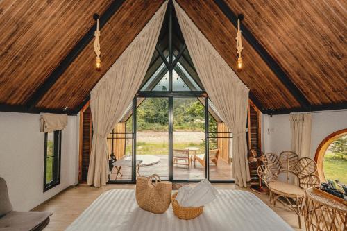 a room with a large window and a table and chairs at นวนิยาย Nava-Niyay in Ban Huai Ti