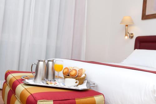 a tray of food and drinks on a bed at Senator Cádiz in Cádiz
