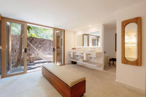 a bathroom with a sink and a large mirror at Luxury Beachfront Stay - 5 Pools! in Careyes