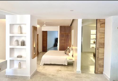 a bedroom with a white bed and a mirror at Luxury Beachfront Stay - 5 Pools! in Careyes