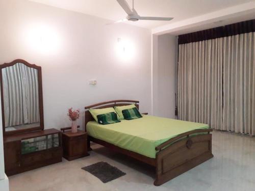 a bedroom with a bed and a mirror at The white house in Kelaniya