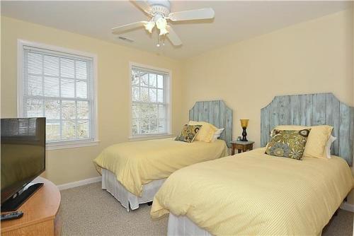 a bedroom with two beds and a flat screen tv at The Happy Heron in West Cape May